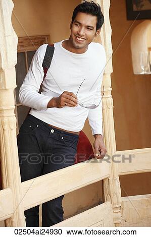 Stock Image - man leaning against a post. Fotosearch