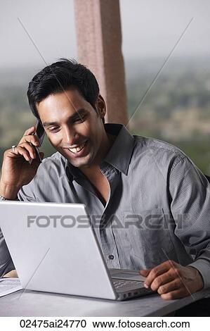 man on phone, working at laptop computer View Large Photo Image Stock Image - man on phone, working at laptop computer. Fotosearch
