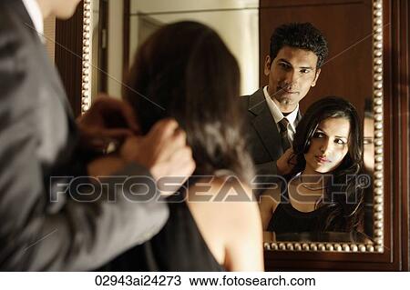 man putting necklace around woman's neck, both looking into mirror View Large Photo Image Stock Image - man putting necklace around woman's neck, both looking into mirror. Fotosearch