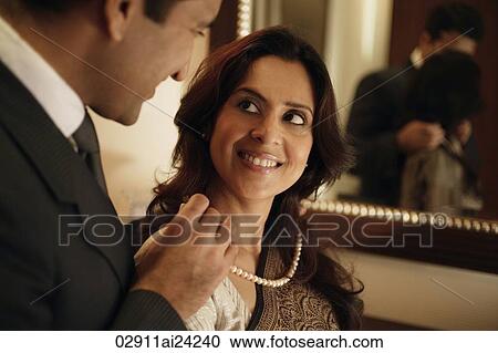 man putting string of pearls around woman's neck View Large Photo Image Stock Image - man putting string of pearls around woman's neck. Fotosearch