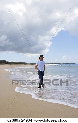 man strolling along shoreline on the beach View Large Photo Image Picture - man strolling along shoreline on the beach. Fotosearch