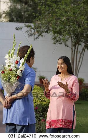 man surprising woman with flowers View Large Photo Image Stock Image - man surprising woman with flowers. Fotosearch