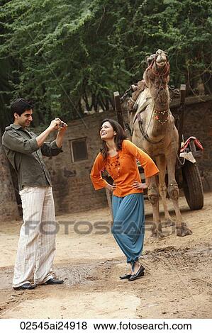 man taking photo of woman in front of camel View Large Photo Image Stock Photo - man taking photo of woman in front of camel. Fotosearch