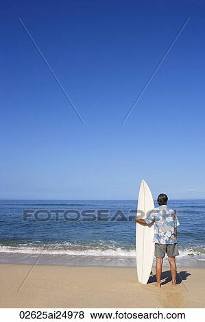 Stock Photo - mature male surfer looking at sea. Fotosearch