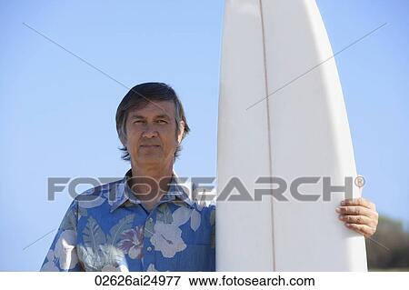 mature man standing next to surf board View Large Photo Image Stock Photo - mature man standing next to surf board. Fotosearch