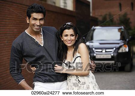 Stock Photo - playful couple standing arm in arm. Fotosearch