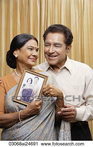 portrait of couple holding photograph, woman in sari and bindi View Large Photo Image Stock Image - portrait of couple holding photograph, woman in sari and bindi. Fotosearch
