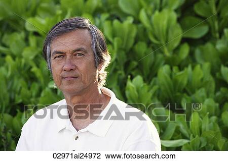 Stock Image - Portrait of mature man, greenery background. Fotosearch