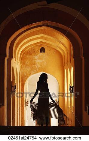 Picture - silhouette of woman in arched hallway. Fotosearch