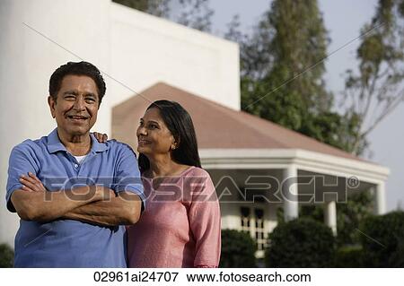 Stock Photo - smiling couple standing in front of house. Fotosearch