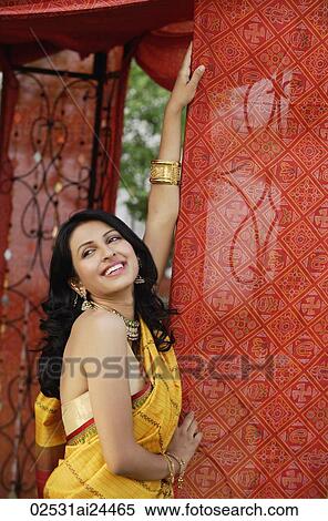 Stock Photography - smiling young woman in sari, red tent. Fotosearch