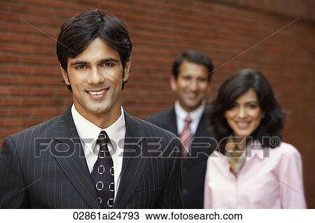 Stock Image - two businessmen and one businesswoman, smiling. Fotosearch