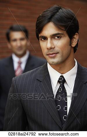 Stock Image - two businessmen, one smiling. Fotosearch