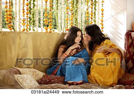 Stock Photo - two young women gossiping, wearing saris. Fotosearch