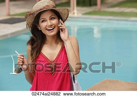 Stock Image - woman at resort, on phone. Fotosearch