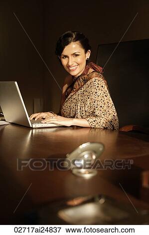 Stock Photo - woman in sari on laptop. Fotosearch