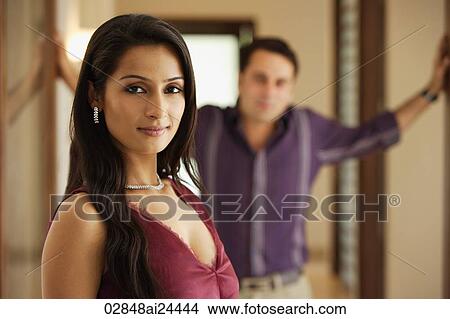 Picture - woman posing with man at background. Fotosearch