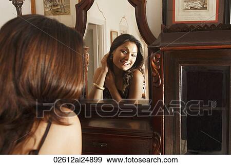 Stock Photo - woman putting earrings on. Fotosearch