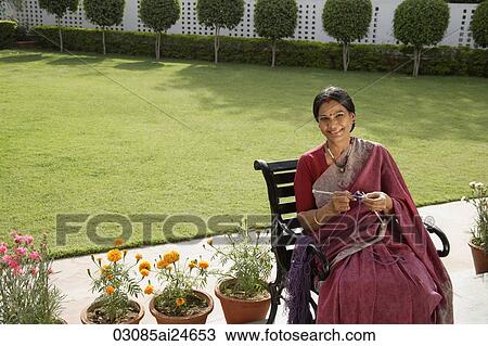 Stock Image - woman wearing a sari, knitting. Fotosearch