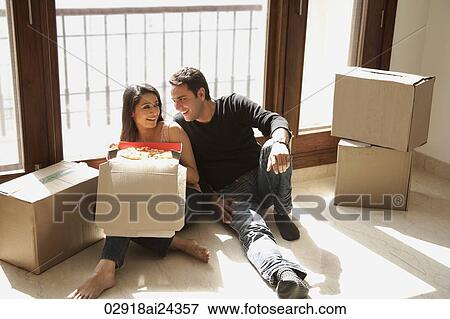 Stock Photo - young couple in new home with moving boxes. Fotosearch