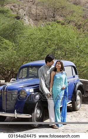young couple looking at each other in front of blue antique car View Large Photo Image Stock Photography - young couple looking at each other in front of blue antique car. Fotosearch