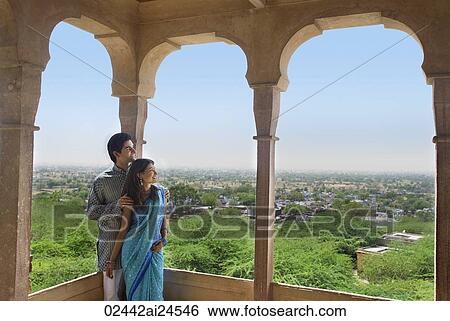 young couple looking out from terrace balcony View Large Photo Image Stock Photograph - young couple looking out from terrace balcony. Fotosearch