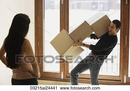 Stock Image - young couple moving into new home. Fotosearch