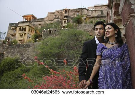 Stock Photography - young couple on balcony, woman in sari. Fotosearch