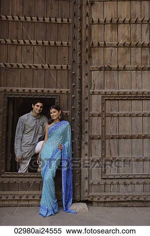 Stock Photography - young couple posing at wooden doorway. Fotosearch