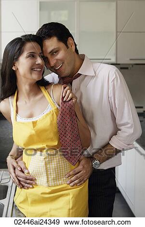 Stock Photo - young couple sharing special moment in kitchen. Fotosearch