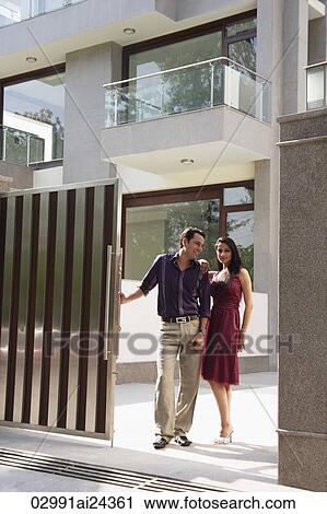 Stock Image - young couple standing at the gate of apartment. Fotosearch