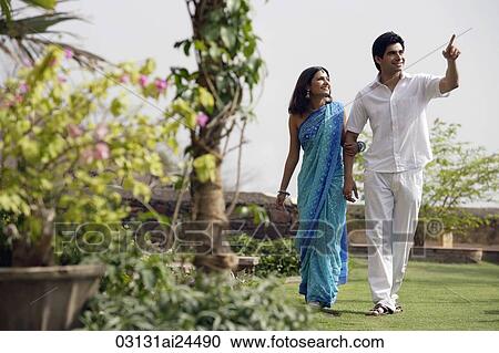 Stock Image - young couple strolling in garden. Fotosearch