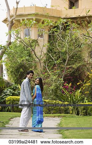young couple strolling in garden, turning back smiling View Large Photo Image Stock Image - young couple strolling in garden, turning back smiling. Fotosearch