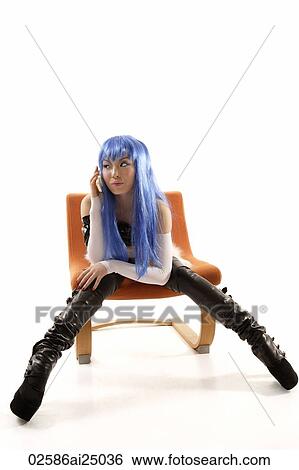 Stock Photograph - young hip lady sitting on chair, look sideway, using mobile phone. Fotosearch