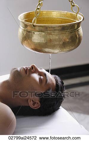 Stock Image - young man having Ayurvedic spa treatment. Fotosearch