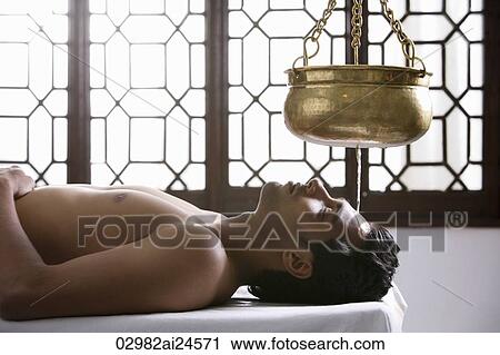 Stock Image - young man having Ayurvedic spa treatment. Fotosearch