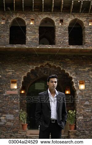 young man in suit standing in front of traditional brick Indian house View Large Photo Image Stock Photo - young man in suit standing in front of traditional brick Indian house. Fotosearch