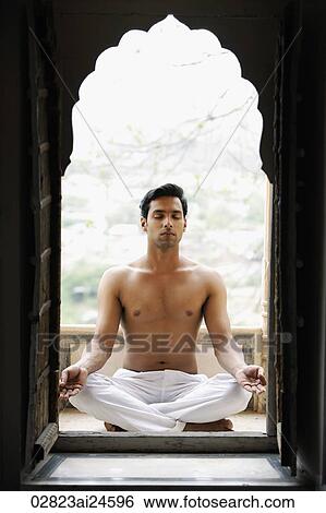 Stock Photograph - young man meditating in doorway. Fotosearch