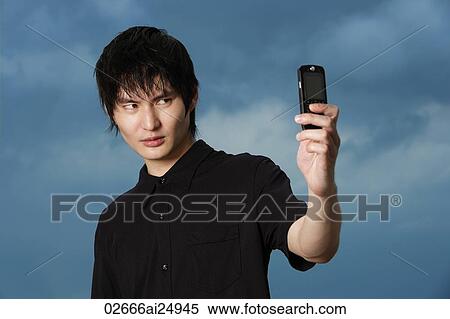 Stock Photography - young man taking own picture. Fotosearch