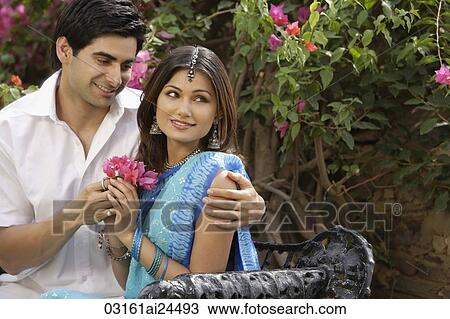 young woman accepting flowers from young man View Large Photo Image Stock Image - young woman accepting flowers from young man. Fotosearch