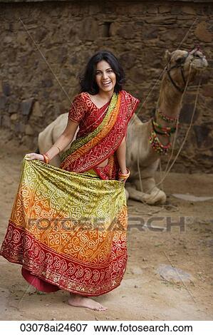 Stock Photo - young woman in sari, in front of camel. Fotosearch