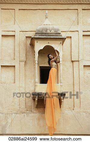 Stock Photo - young woman in sari, on balcony. Fotosearch