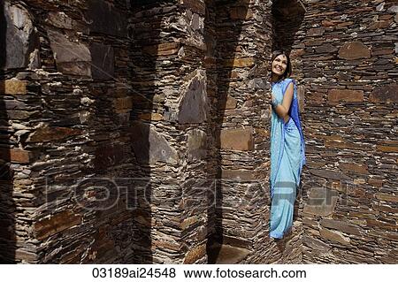 young woman in sari, peeking from behind brick pillar View Large Photo Image Stock Photo - young woman in sari, peeking from behind brick pillar. Fotosearch