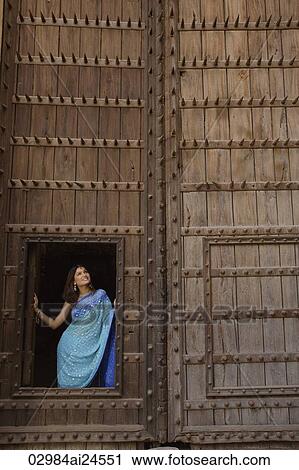 young woman in sari, standing at opening of huge wooden doorway View Large Photo Image Stock Image - young woman in sari, standing at opening of huge wooden doorway. Fotosearch