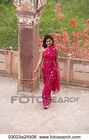 Stock Photograph - young woman in sari, walking away from balcony. Fotosearch