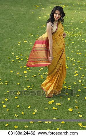 Stock Image - young woman in yellow sari. Fotosearch