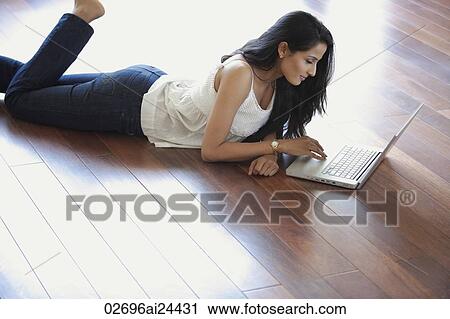 young woman laying on floor using laptop View Large Photo Image Stock Image - young woman laying on floor using laptop. Fotosearch