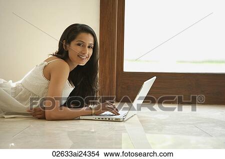 Picture - young woman on floor with computer. Fotosearch