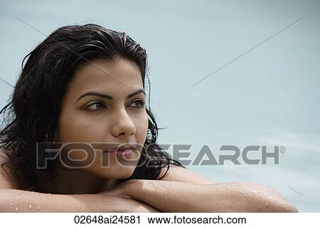 Stock Image - young woman resting poolside. Fotosearch