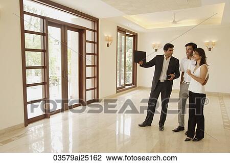Stock Image - agent with young couple. Fotosearch
